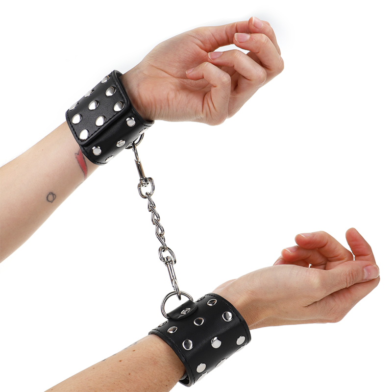 img_187357_d1ace36dda9bc32343b4f3334f43d73a_1 KINK - WRIST RESTRAINTS WITH SNAP FASTEN FULL OF RIVETS BLACK ADJUSTABLE 19-24 CM X 5.5 CM - Image 1